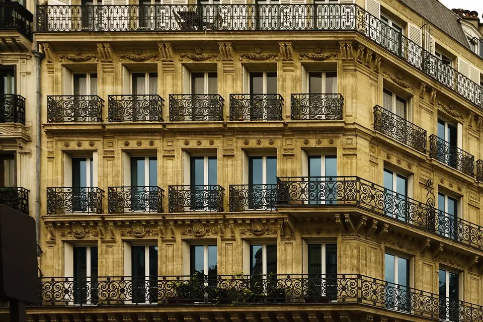 Façade d'un immeuble haussmannien en pierre de taille avec ses balcons en fer forgé sur plusieurs étages