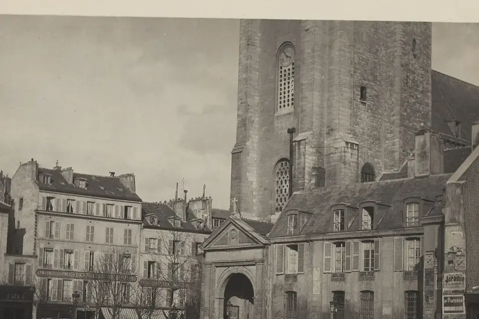 Photographie ancienne en noir et blanc de la place et du portail de l'église Saint-Germain-des-Prés, avec des immeubles et quelques passants